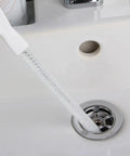 Sink Drain Overflow Cleaning Brush 17.7 Inch Long Flexible Hair Catcher in use, shown cleaning a sink drain with spiral bristles.