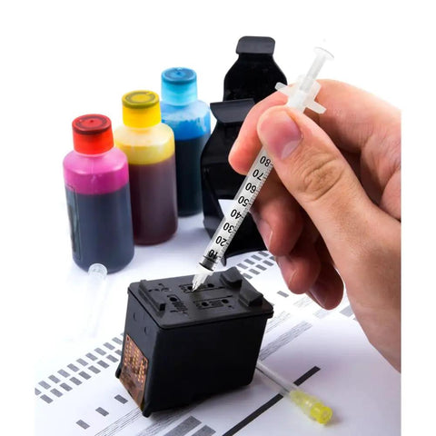 Hand using a syringe needle to fill an ink cartridge next to colorful bottles, 25G 5/8 Luer Lock Syringe Needles in action.