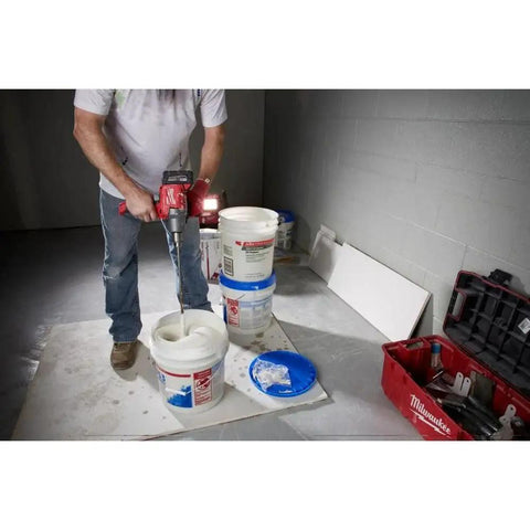 Worker using 18V Cordless Mud Mixer Bare Tool for Drywall Mud Plaster and Concrete Projects, mixing in a bucket on jobsite