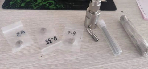Waterjet cutting head components for DIY (front view); metal nozzle body with mixing chamber and clear sleeves labeled 0.4/0.35