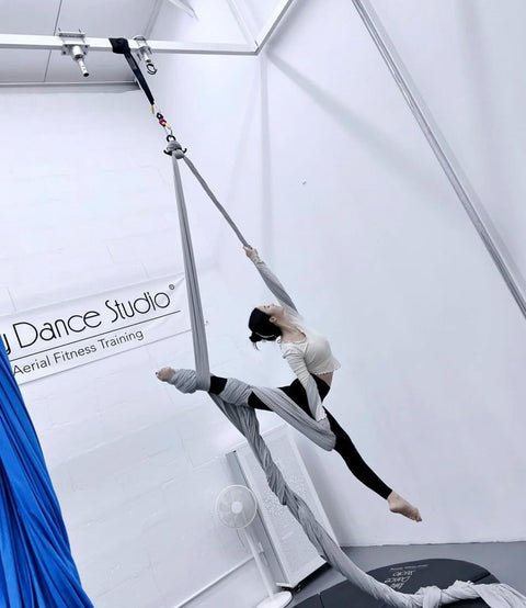 Aerial artist performing with Two Pack Black Endless Round Slings Heavy Duty Polyester Lifting Slings With 5300 Lbs Vertical Capacity 4240 Lbs Choker Capacity And 10600 Lbs Basket For Rigging Towing Construction Two Feet in a dance studio.