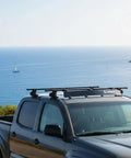 Heavy Duty Universal Roof Rack Bar Cover In Matte Black Aerodynamic Shell on pickup truck at seaside, 40 inches wide.