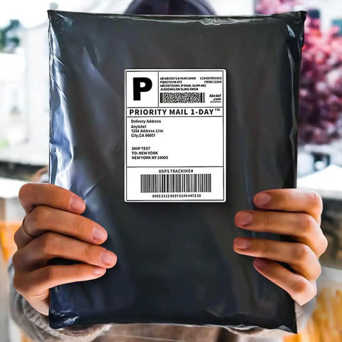 Person holding a sealed Black Poly Mailers 12x15.5 Inches 500 Pack Self Sealing Waterproof Tear Resistant Shipping Envelope