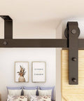 Close-up of ceiling mount sliding barn door hardware kit for closet, showing beefy steel rail and nylon wheel rollers for smooth operation.