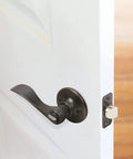 Springdale Privacy Bed And Bath Door Lever in Oil Rubbed Bronze on white door showing reversible handle for left or right doors