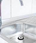 Rubber Bathtub Drain Plug with Stainless Steel Easy Pull-Out Stopper installed in a stainless steel sink with faucet.