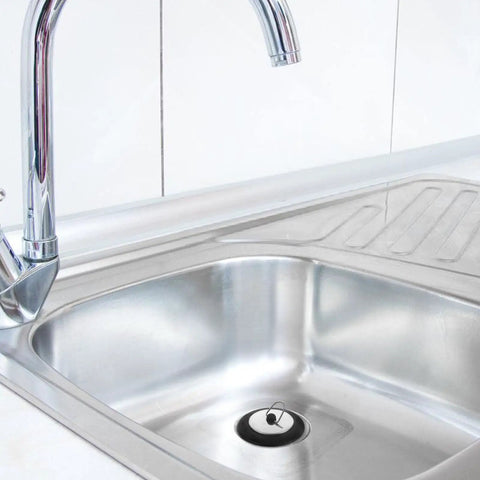 Rubber Bathtub Drain Plug with Stainless Steel Easy Pull-Out Stopper installed in a stainless steel sink with faucet.