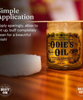 Real Deal Universal Surface Finish For Wood Leather Plastic Vinyl And Metal That Is Straight Up Waterproof And Food Safe While Acting As A Hella Solid Solvent Free Non Toxic Protection Layer Inside A Handy Four Ounce Jar For Instant Glow Ups displayed next to a buffing pad.