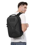 Person wearing Hard Shell Waterproof Camera Backpack For DSLR SLR And Mirrorless Gear With Tripod Holder And Laptop Compartment Fits 15 To 16 Inch Laptops Durable Travel Case For Canon Nikon Sony Black