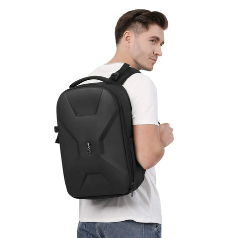 Person wearing Hard Shell Waterproof Camera Backpack For DSLR SLR And Mirrorless Gear With Tripod Holder And Laptop Compartment Fits 15 To 16 Inch Laptops Durable Travel Case For Canon Nikon Sony Black