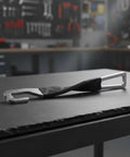 Heavy Duty Stainless Steel Rear Door Stopper Hook For Outdoor Adventures And Tailgating Fits Most Traps With Leather Cover Vent Tool Kit on a workbench.