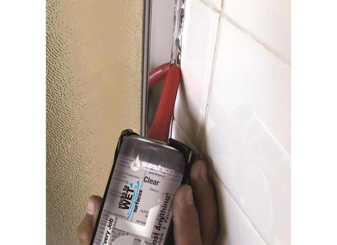Applying Lexel Clear Sealant 5-Ounce Co-Polymer Rubber Adhesive Caulk to wet shower tile edge for indoor sealing.