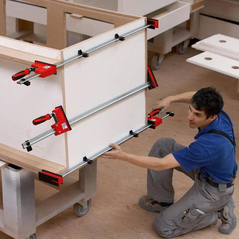 Heavy Duty 31 Inch Fixed Jaw Parallel Clamp Boasts Rock Solid Zero Sag Grip With Non Marking Pads being used for woodworking.