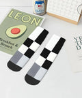 Black And White Checkerboard Straight Tube Socks Crafted From Buttery Soft Polyester For Elite Breathability And Quick Dry Comfort A Dead Set Classic For The Daily Grind Or Weekend Chill Sessions on a table with trendy decor.