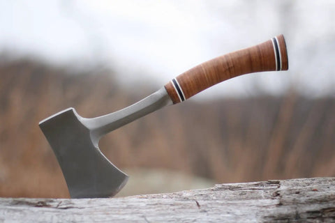 Sportsman's Axe 14 Inch Hatchet For Camping And Outdoors with forged steel head and leather grip on a log