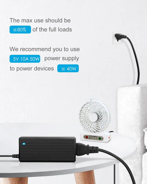 Beefy 5V 10A DC Power Supply For LED Strip Lights 50W converter plugged in, powering a small fan on a table