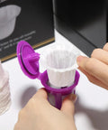 Hands placing disposable K Cup coffee filter from 200 Count For Keurig 1.0 And 2.0 Brews into reusable pod for easy cleanup
