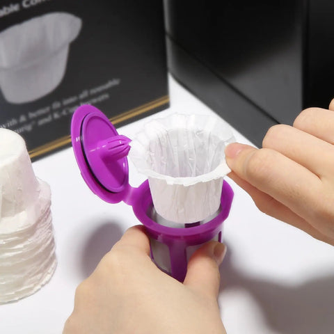 Hands placing disposable K Cup coffee filter from 200 Count For Keurig 1.0 And 2.0 Brews into reusable pod for easy cleanup