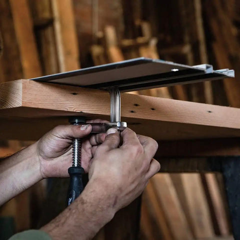 Hands securing a guide rail clamp 2 pack for track saws, sturdy no slip grip that holds rails firmly in place on a wooden surface