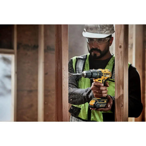 Worker using Compact Cordless Hammer Drill Kit With Brushless Motor, 20V Max Power, Half Inch Chuck, drilling through wood frame.