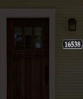 Reflective Address Numbers Sign With High Visibility Panels Weather Resistant Easy Mount For Front Porch Or Mailbox Post Boost Your Curb Appeal And Help Visitors Find Your Home At Night displayed beside a front door at night.