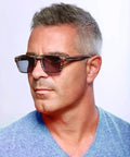 Top Tier Faux Wood Bifocal Reading Sunglasses With Plus 1.50 Power And Full Sun Blocking Spring Hinge Frames worn by a man in a blue shirt.