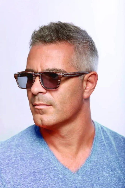 Top Tier Faux Wood Bifocal Reading Sunglasses With Plus 1.50 Power And Full Sun Blocking Spring Hinge Frames worn by a man in a blue shirt.