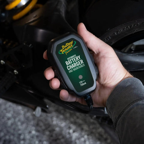 12V Smart Battery Charger And Maintainer For Powersports Riders Straight Up Restoration Of Motorcycles ATVs And UTV Batteries held in hand.