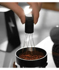 Level Up Your Daily Grind With This Adjustable Wdt Espresso Coffee Stirrer Featuring Rotating Needle Spread Magnetic Holder And Six Spare Tips For Flawless Shots No Cap, hand holding tool over coffee grounds.