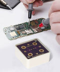 Hands using 4-Wire Short Socket Multimeter Verification Tool For DMM With Resistance Calibration And Gold Plated PCB on circuit board.