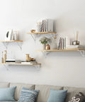 Wall-mounted shelves on living room wall supported by Heavy Duty 12-Inch By 8-Inch Shelf Brackets With 600 Lb Capacity 10 Pack White Metal L Supports.