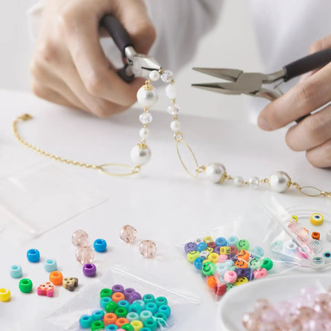 Person crafting jewelry with beads, Clear 3 By 3 Inch Reclosable Zip Bags Pack Of 1200 2 Mil Thick Food Safe Poly Bags visible on side.