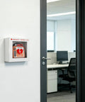 Top Shelf Steel AED Wall Mount Cabinet With Clear Front Panel For Immediate Automated External Defibrillator Access, mounted in an office.
