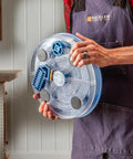 Person holding Pro Grade Saw Blade Cleaning Kit For Circular Table And Miter Saws 6 1/4 To 12 Inches with clear dish and grips