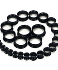 Dope Black Silicone Ear Gauges Set With 15 Pairs And 24 Pieces Stretching Kit For Ear Tunnels From 2G To 25mm arranged in a spiral