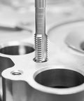 Close-up of 80-Piece Tap And Die Set With Metric And SAE Taps And Dies Heavy Duty Bearing Steel Threading Kit cutting threads in metal.