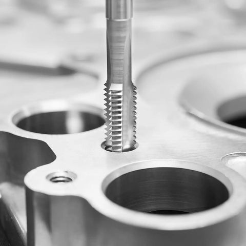 Close-up of 80-Piece Tap And Die Set With Metric And SAE Taps And Dies Heavy Duty Bearing Steel Threading Kit cutting threads in metal.