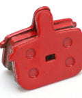 Close-up view of a red semi-metallic disc brake pad, part of the Eight Pack SemiMetallic Disc Brake Pads For Mountain And Electric Bikes Durable Low Noise High Heat Resistant Bicycle Brake Pad Replacement Set For Smooth Stops And Long Life.