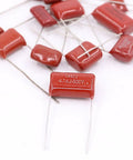 Close-up of 150 Piece CBB Metallized Polypropylene Film Capacitor Kit 400V-630V Range 10nF To 68nF, showing red radial leads.