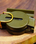 Durable Wilderness Survival Compass for Orienteering and Outdoor Navigation, folded on wood, plastomer with floating dial