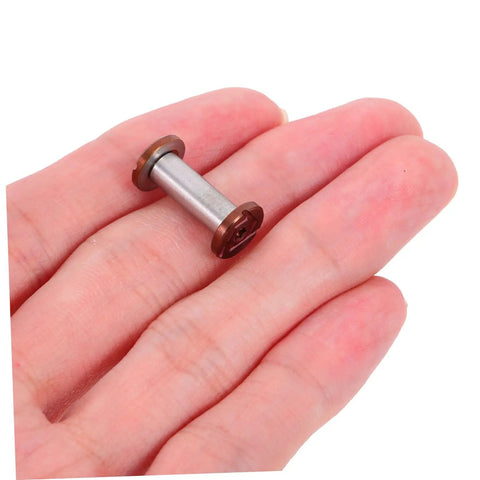 Top Shelf Stainless Steel Knife Handle Screws For Quick Blade Fabrication Featuring Straight Slot Notch Built Tough For Solid Fit On Chef Utility And Parer Knives Real Deal Supply held in hand close-up view.