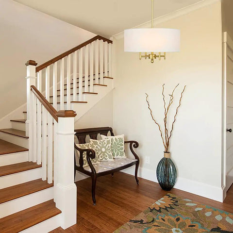4 Light Gold Modern Drum Chandelier With White Linen Shade 17.7 Inch Pendant Light Fixture in stylish foyer setting.