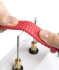 Hands using the 30W Compact Electric Hot Tool Quick Heating Seam Smoother on red woven cord for sealing fabric edges.
