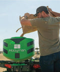 Man using Vehicle Spreader With Adjustable Feed Rate And Universal Attachment for Trucks and Off Road Rigs, 125Lb Hopper in field