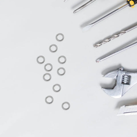 Heavy Duty Stainless Steel Split Lock Washers M6 300 Piece Pack resting among tools on a white surface.