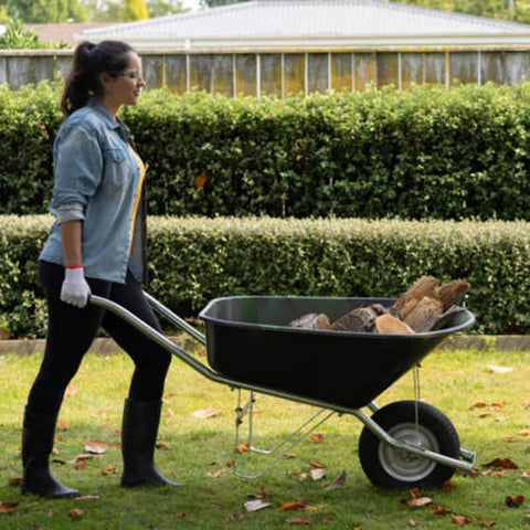 Woman moving a wheelbarrow with 2-Pack Pneumatic Air Filled 10 Inch Hand Truck Wheels With 4.10/3.50-4 Tires in garden