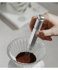 Top Shelf Telescopic WDT Tool For Espresso Distribution With 8 Bonus Stainless Steel Needles Adjustable Barista Stirrer in use stirring coffee grounds.