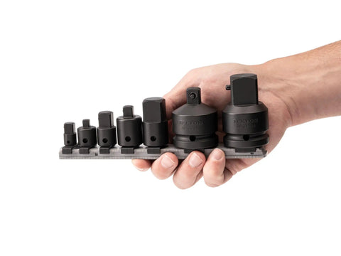 Hand holding 7-piece 1/4 to 3/4 inch drive impact adapter and reducer set with rail for automotive and workshop use