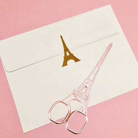 Rose Gold Desk Accessories Set With Scissors Staple Remover And Two Letter Openers For Home Office Vibe Luxury Rose Gold Office Supplies And Desk Decor Functional And Glam featuring Eiffel Tower design scissors on pink background with envelope.