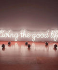 Living The Good Life LED Neon Sign Custom Personalized Home Wall Decor Large 30 Inch Indoor Light warm white glow on wood floor.